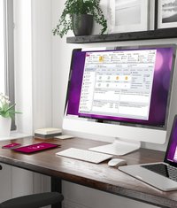 Computer und Laptop stehen auf einem Schreibtisch